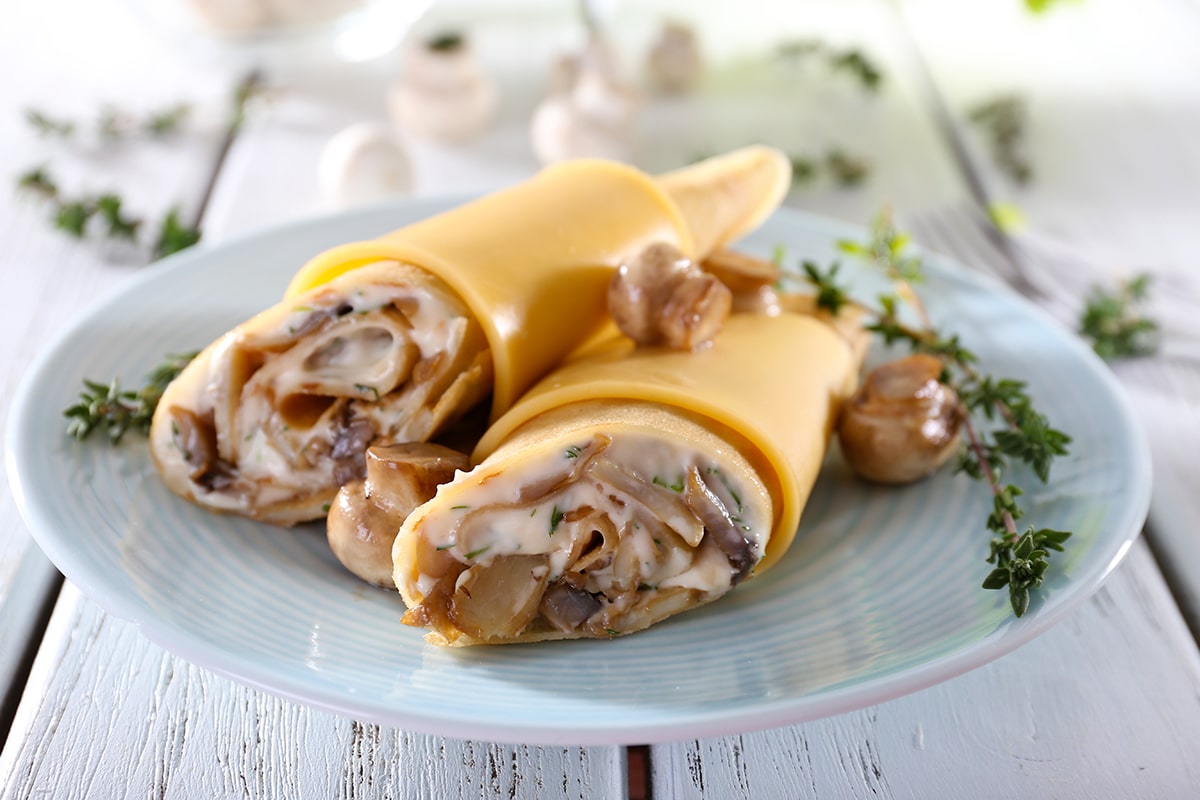 Připravte si náplň z hub a sýra a zabalte ji do palačinek. Získáte tak chutné jídlo k obědu nebo večeři.